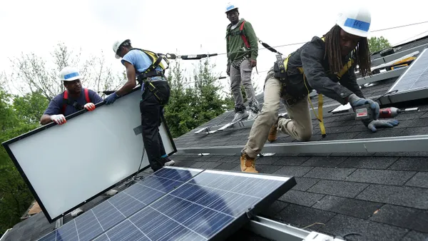 People installing rooftop solar panels.