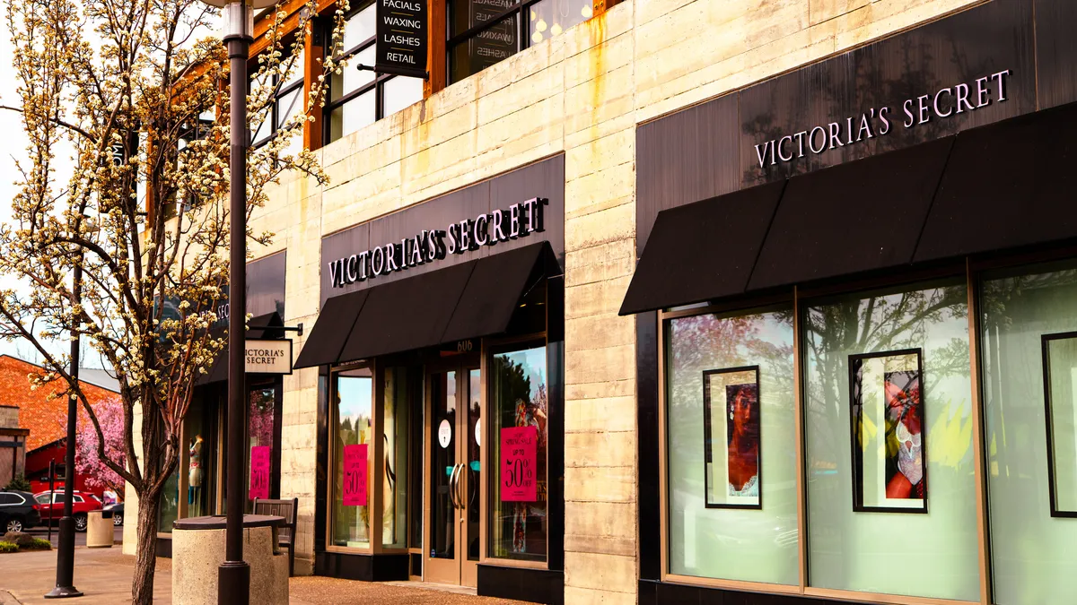 A small leafy tree flanking a Victoria's Secret store.