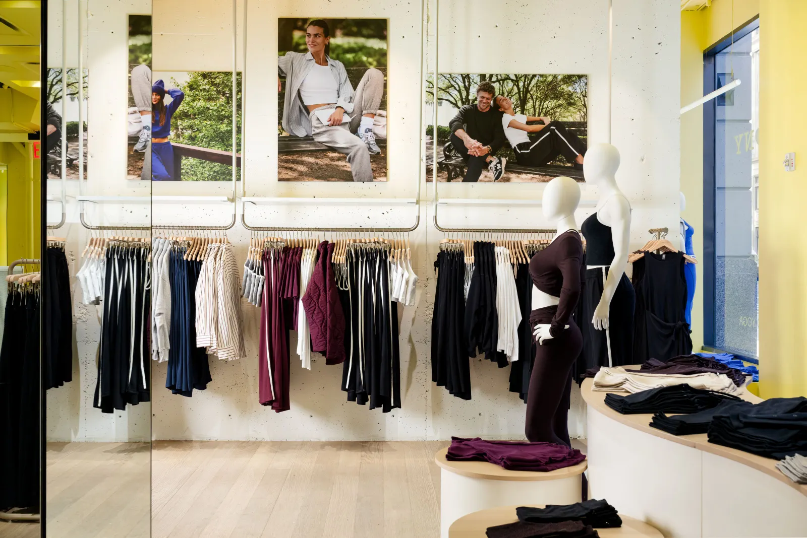Beyond Yoga active apparel on display in a store under photographs of smiling people.