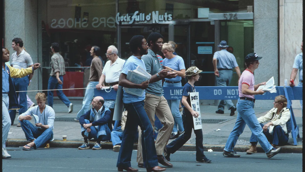 Two Black men in focus walk the streets on Labor Day