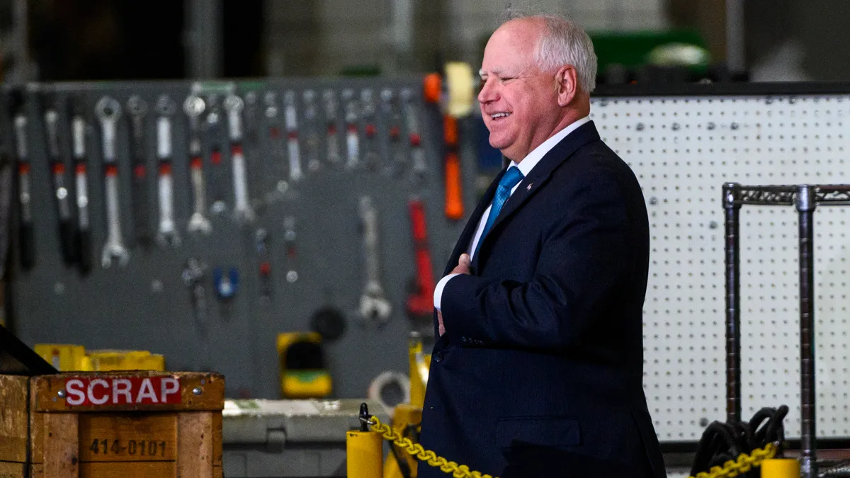 Minnesota Gov. Tim Walz walks in a maintenance area of a truck facility