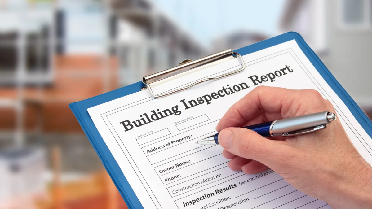 A building inspector is completing an inspection form on clipboard.