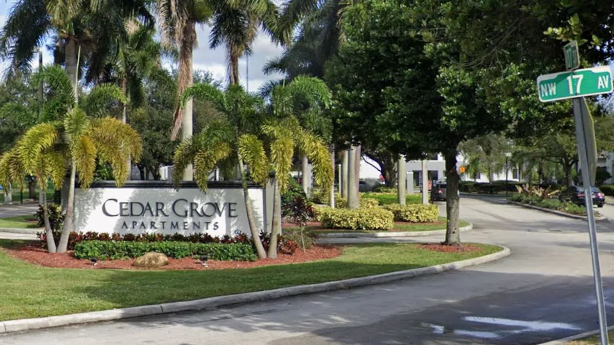 A lawn with a sign reading "Cedar Grove Apartments."