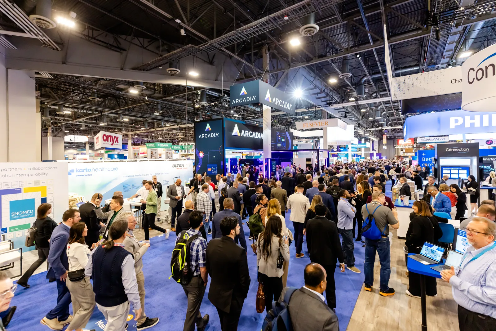 A crowd of people enters the HIMSS exhibit hall.