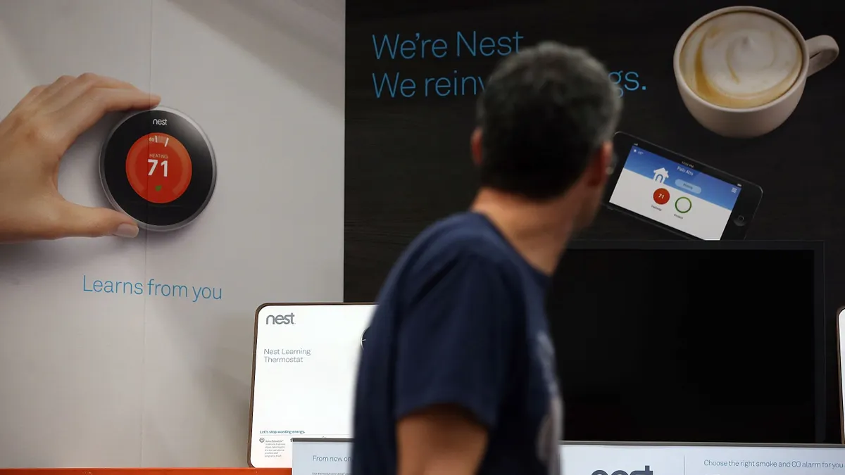 A person walks by a diplay for the Nest smart thermostat at a Home Depot store