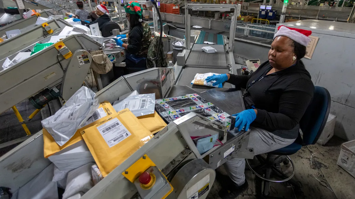 U.S. Postal Service workers scan parcels at the Los Angeles Processing and Distribution Center on December 11, 2019 in Los Angeles, California.