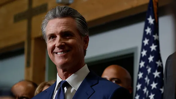 A close-up shot of Gov. Gavin Newsom while he smiles.