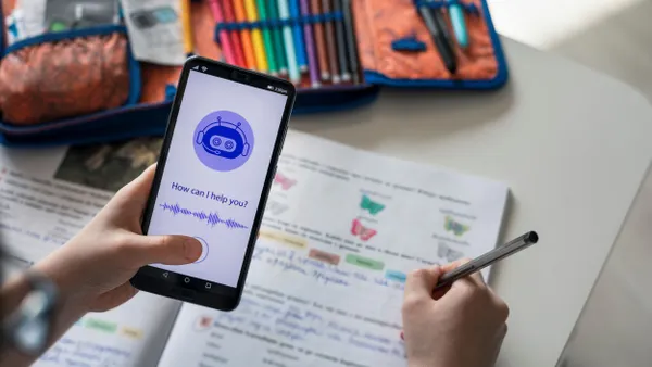 A student holds a phone while using an AI chatbot to do their homework.
