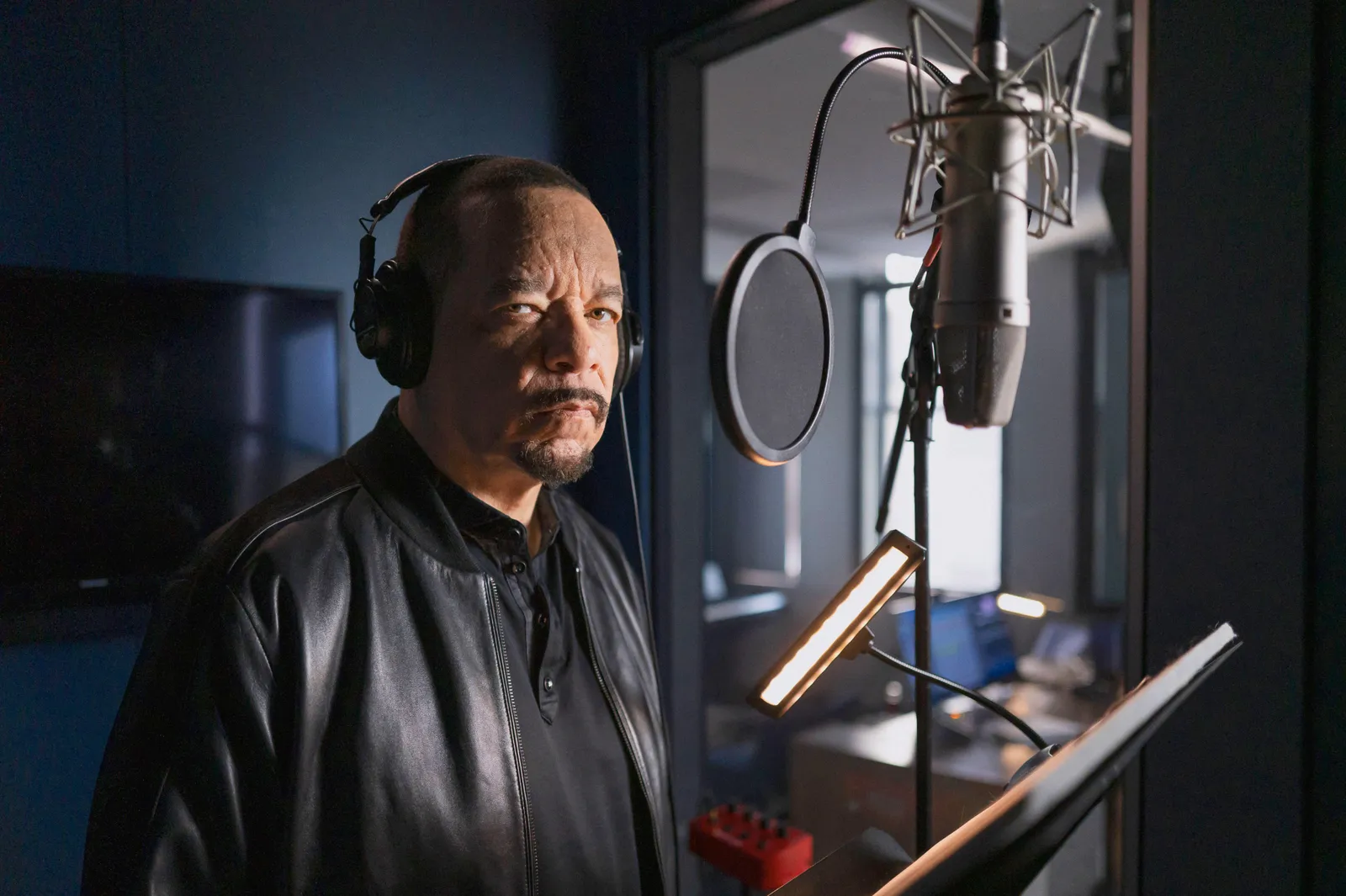 Actor Ice-T stands in a recording studio with headphones on.