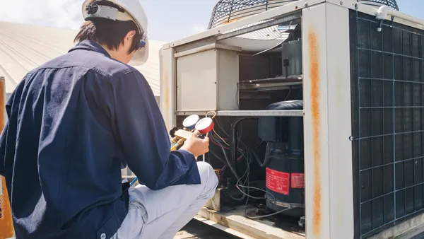 A worker performs diagnostics on an HVAC unit.