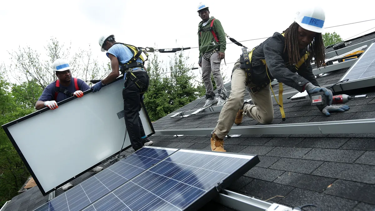 People installing rooftop solar panels.