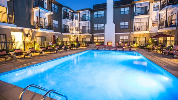 A swimming pool with an apartment building in the background