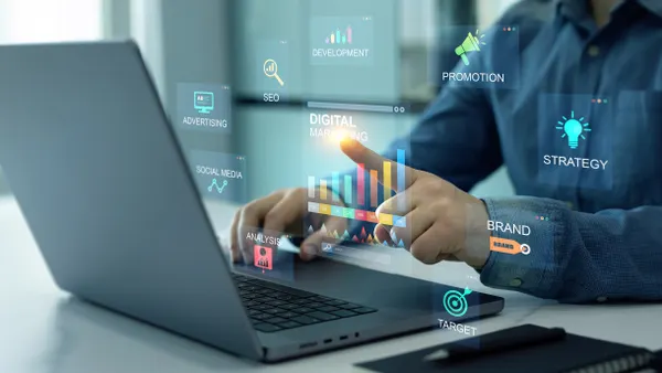 Man at laptop conducting digital marketing with social media, email, website and channel search engines.