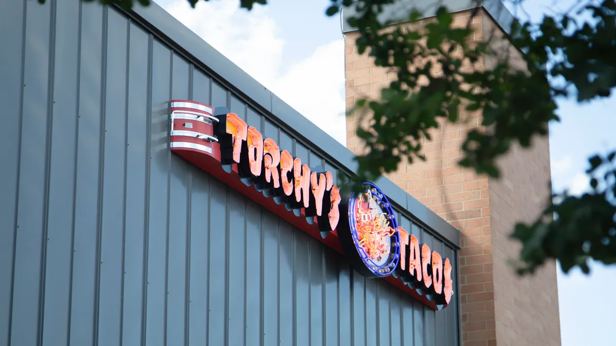 A Torchy's Tacos sign shot from a low angle.