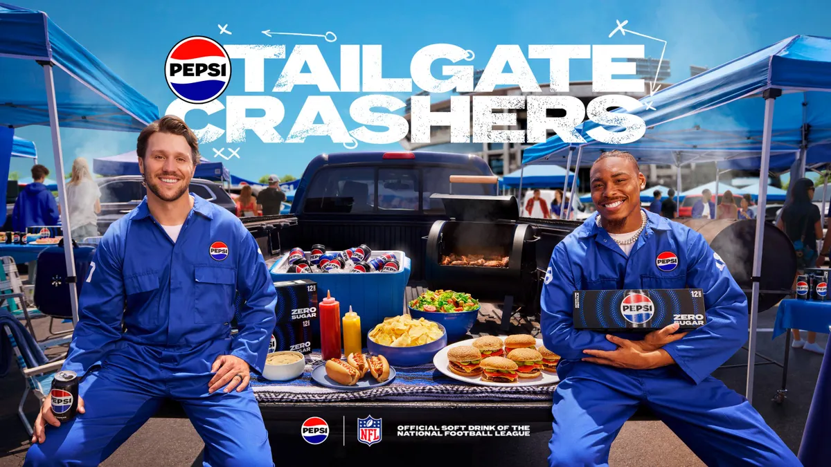 NFL players Josh Allen and Justin Jefferson sit at a tailgate in a parking lot wearing blue Pepsi jumpsuits
