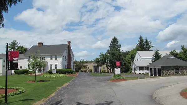 Broad view of housing structures on college campus with signage.