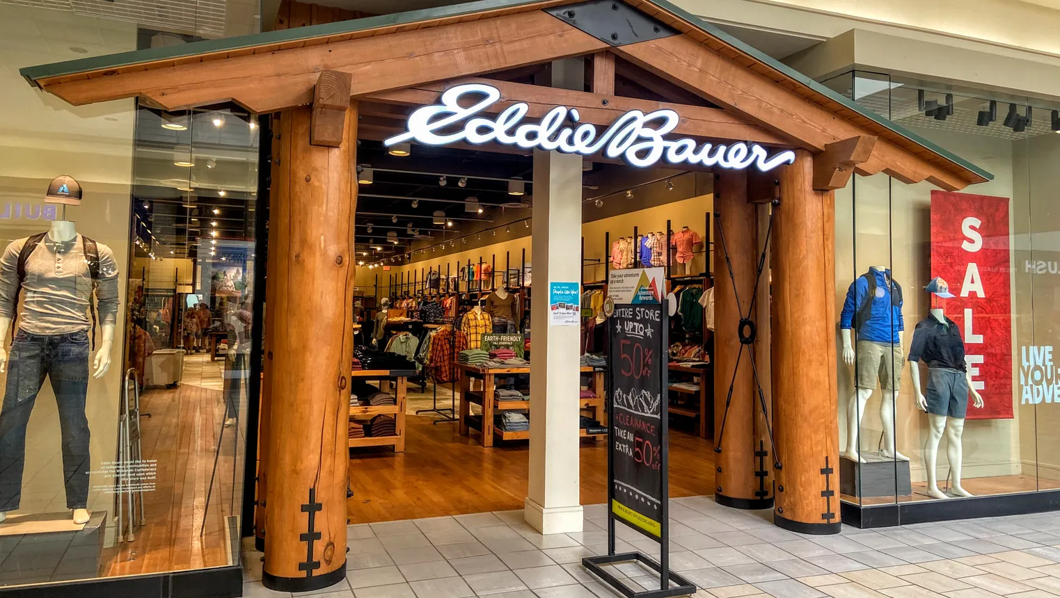 An Eddie Bauer mall store entrance mimics a log cabin, with faux wooden pillars and pitched roof.