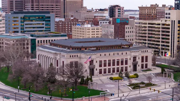 Aerial view of a stone building surrounded by other buildings.