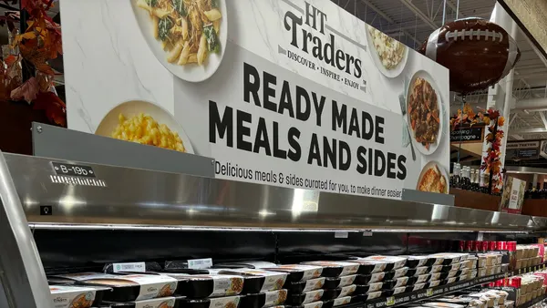A sign above food in a grocery store.