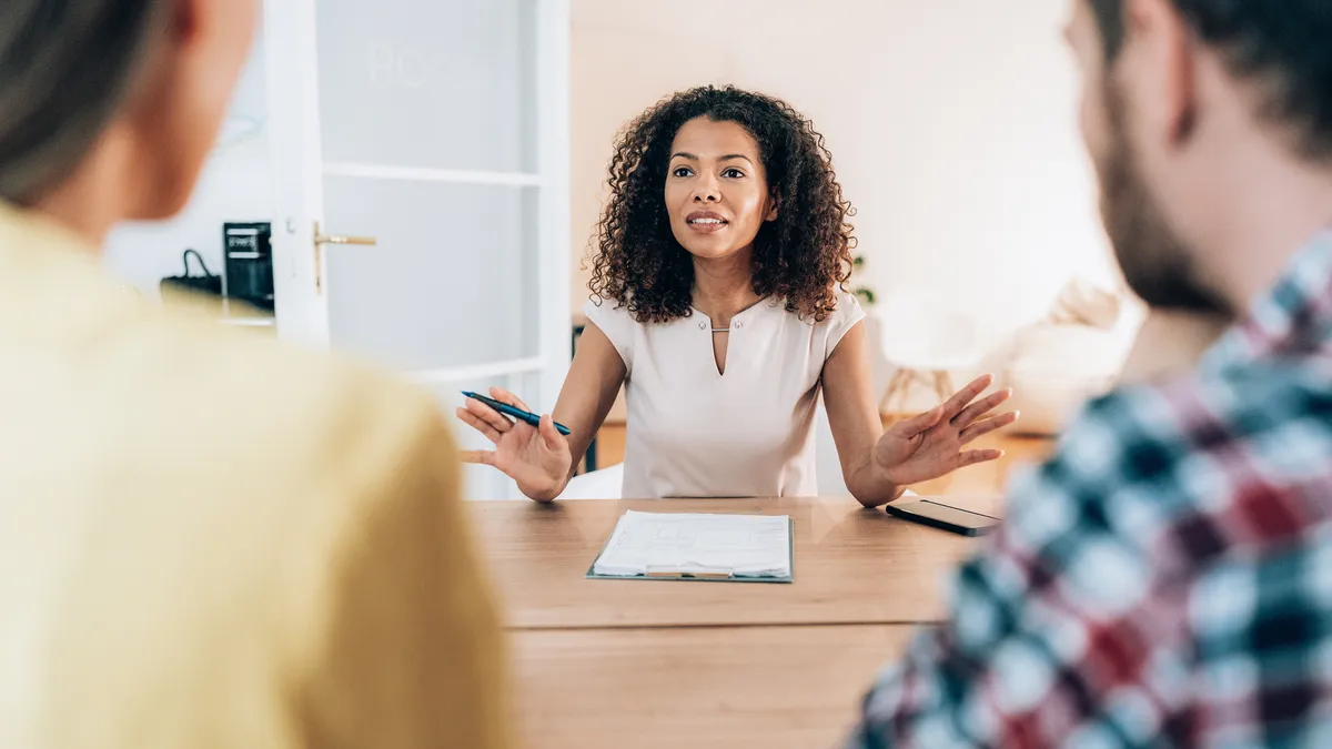 Businessperson talks with colleagues during a meeting