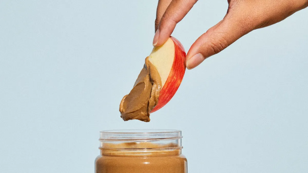 An apple dipped in Voyage Foods' peanut-free peanut butter