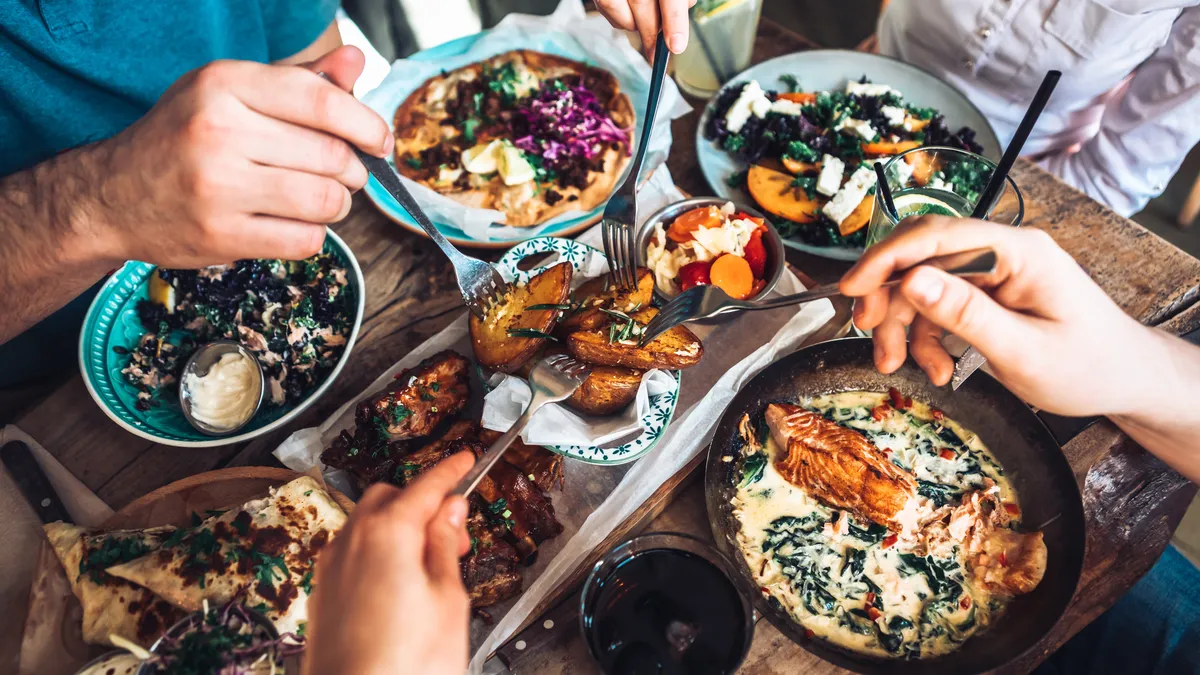 People sharing a dish around a table