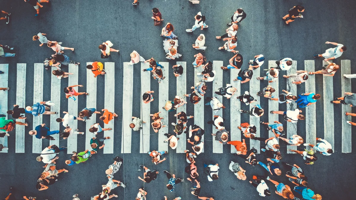 Overhead view of many pedestrians in a crosswalk.