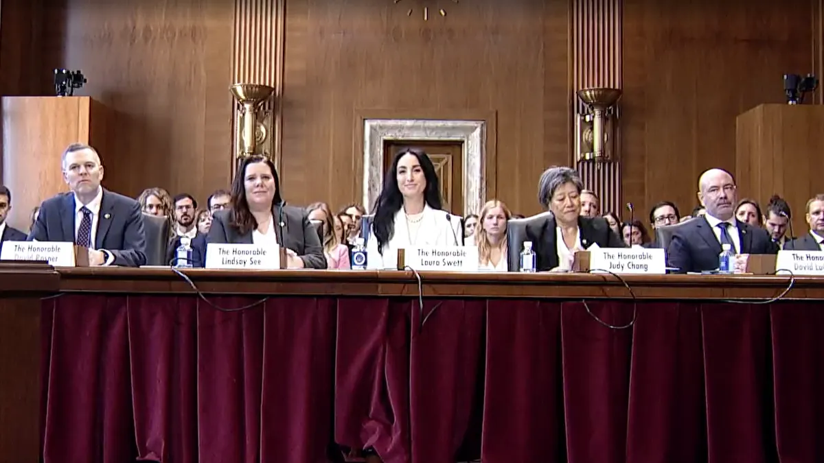 A group of people sit at a large desk.