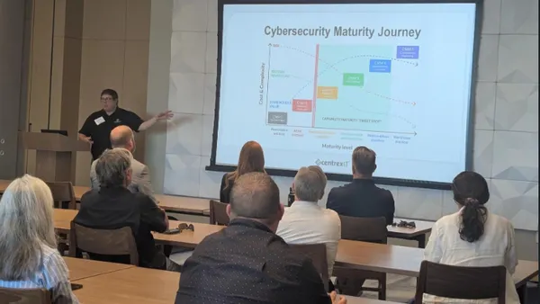 man speaking at a whiteboard in front of sitting people