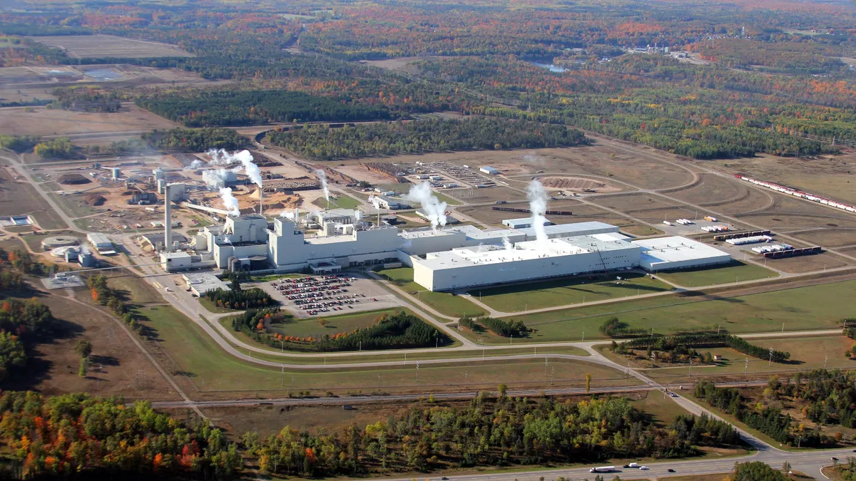 A wide exterior shot of an industrial facility surrounded by green space.