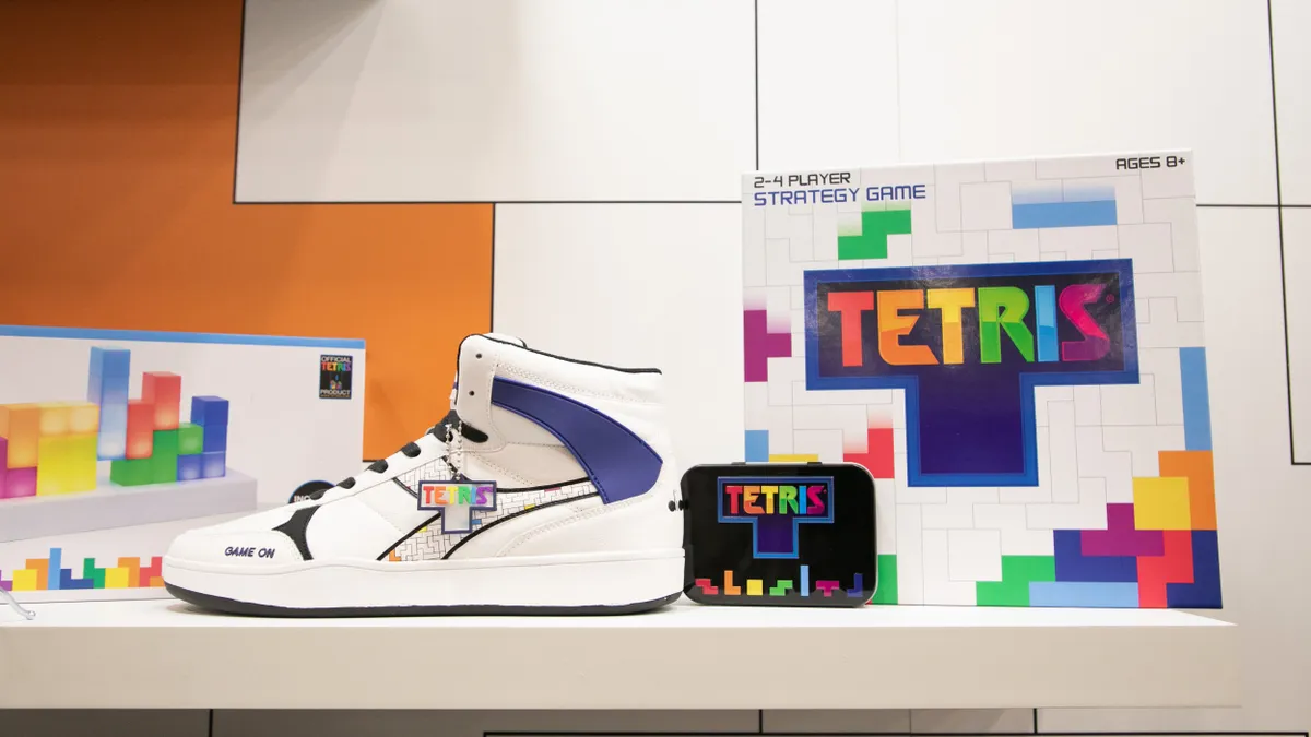 A Tetris brand show and the Tetris game box sitting on a white shelf.