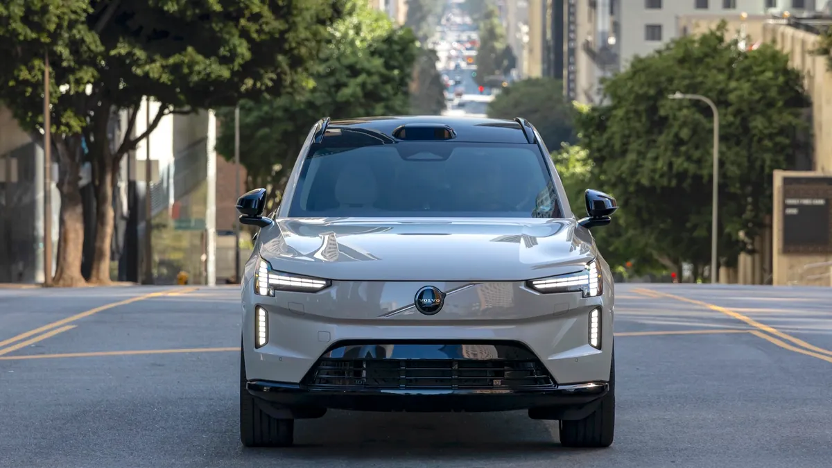 A Volvo EX90 electric SUV faces ahead into traffic, equipped with Luminar lidar for future autonomous-driving upgrades.