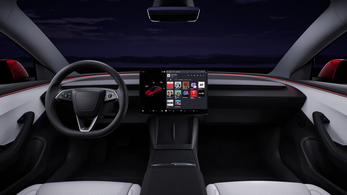 The interior of the Tesla Model 3 showing the dashboard, steering wheel and center display screen.