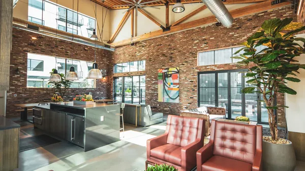A lounge space with lots of seating and a kitchen counter.