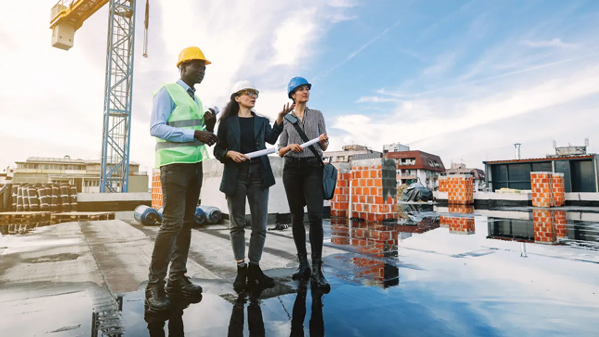 Three architects planning construction site map