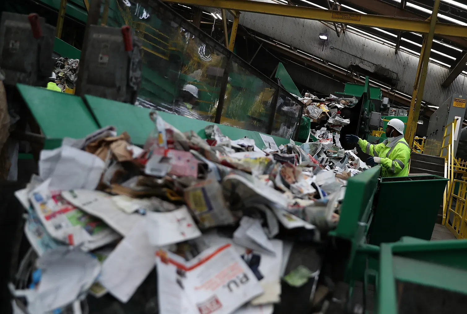 Workers sort recyclables on a conveyor.