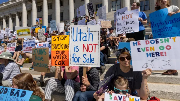 Protesters hold signs in front of the Utah State Capitol