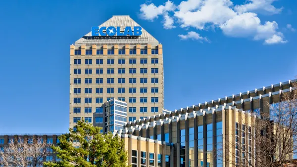 A tall building in the center with the blue Ecolab logo sign on top of it.