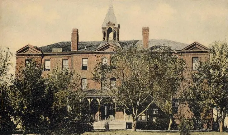 Old photograph of large brick building.