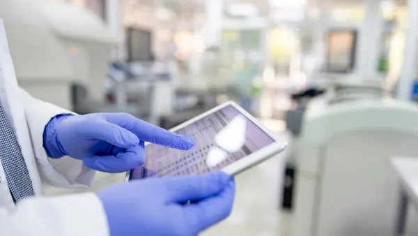 Close-up on a scientist using a mobile app on a digital tablet while working at the laboratory