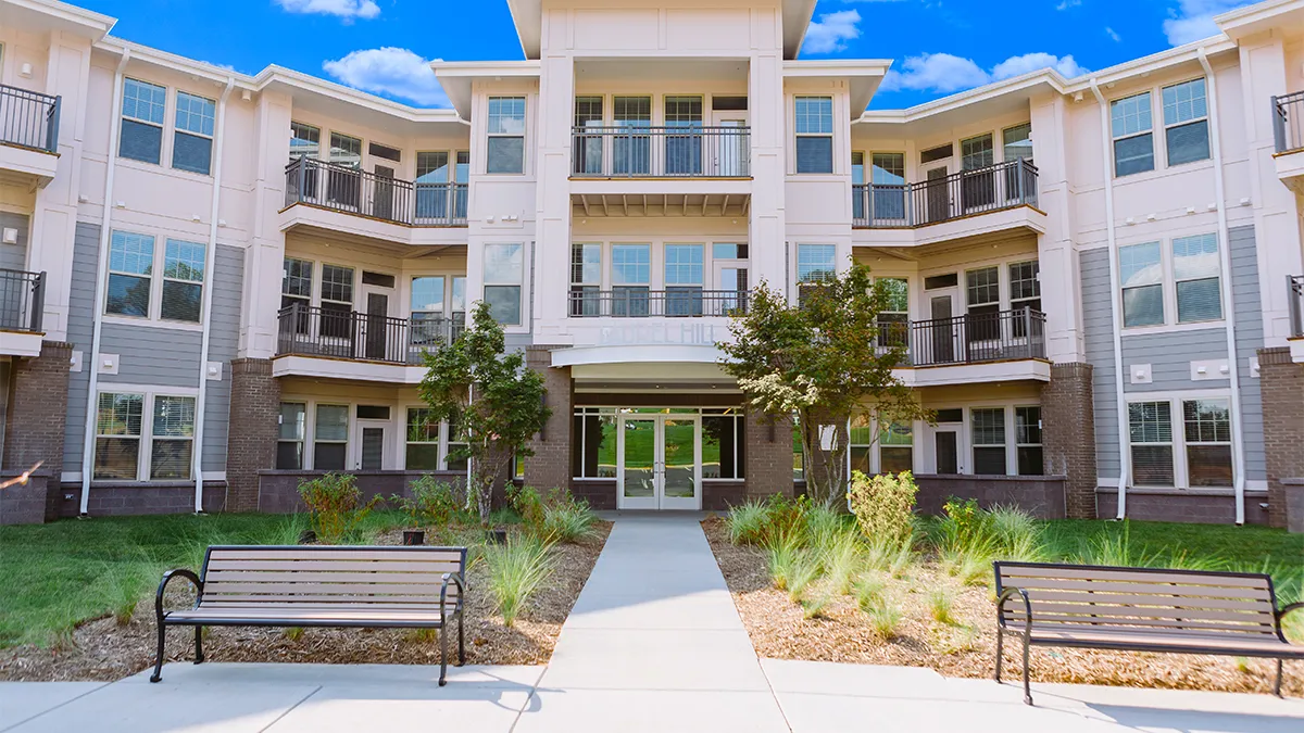 Three story brown apartment building.