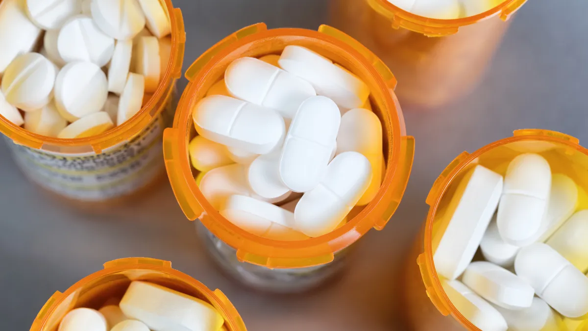 Close up overhead view of full prescription bottles on stainless steel background