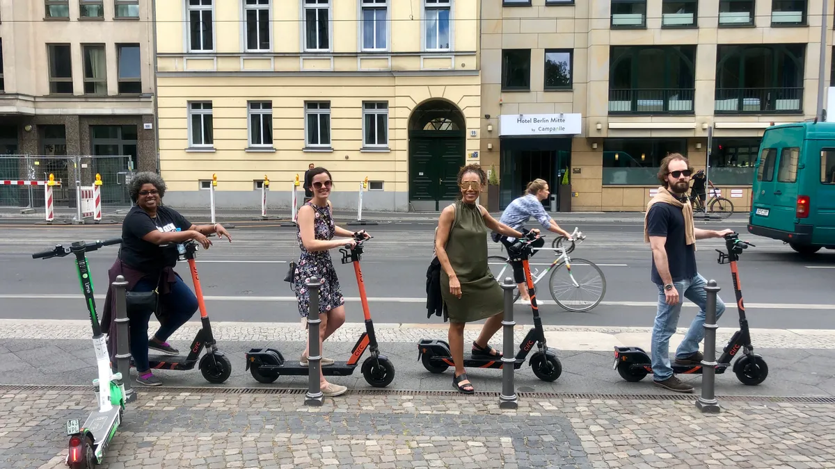 Joe Hennessey, the 2019 Maine Teacher of the Year, rides a scooter in Berlin, Germany with other state teachers of the year.