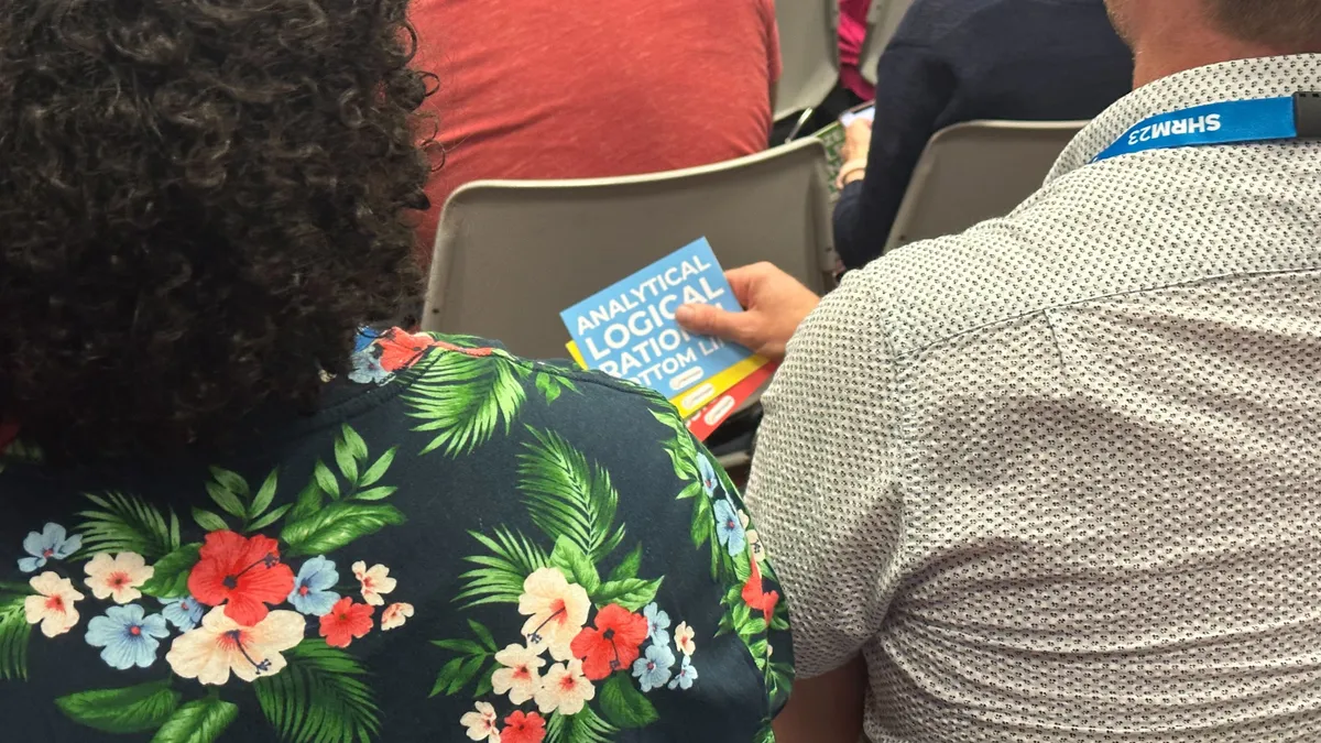 Session attendees hold cards indicating personality types at a SHRM23 session.