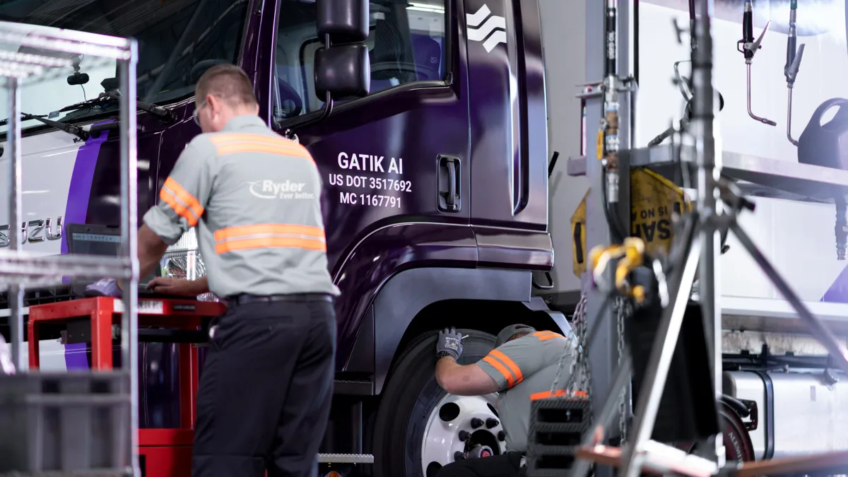 Ryder techs work alongside a Gatik autonomous truck in a maintenance shop.