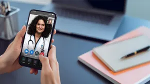 A woman talking to a doctor via a video chat on her smartphone using the Amwell platform.