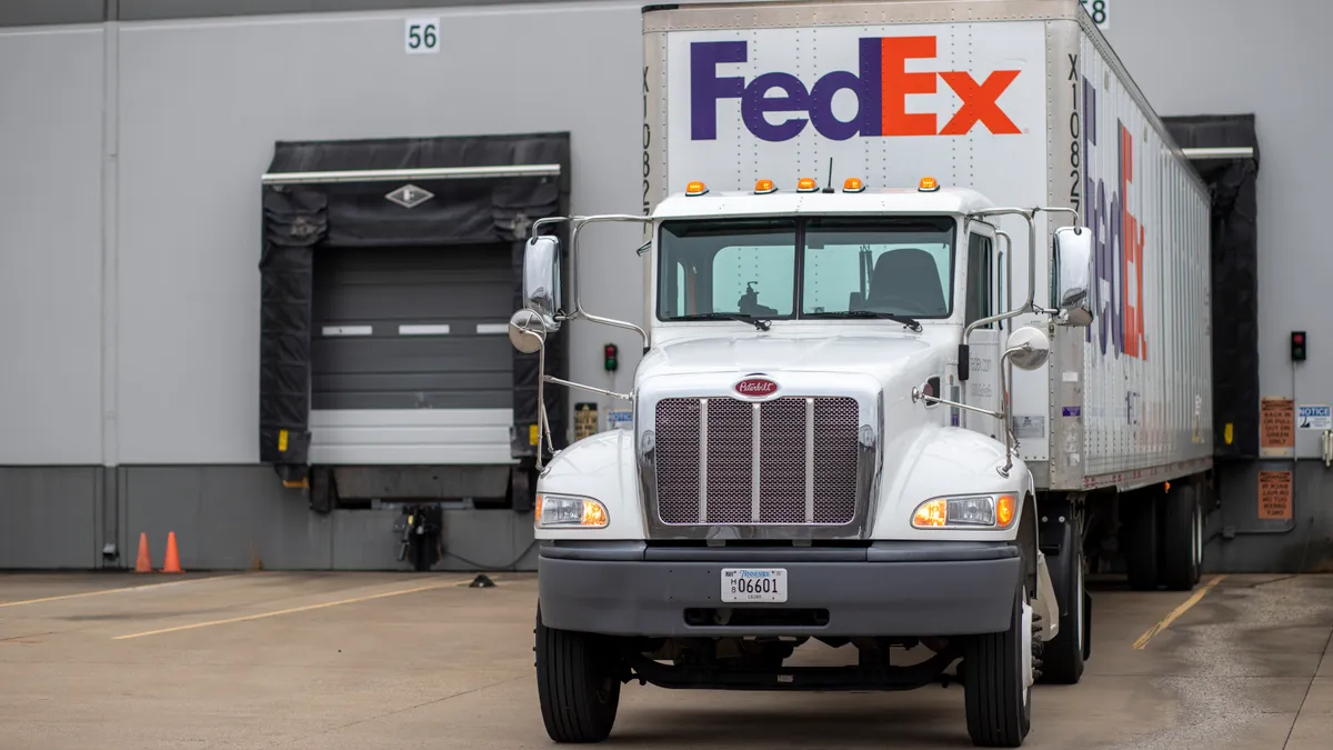 A FedEx Freight truck is stationed at a dock door.