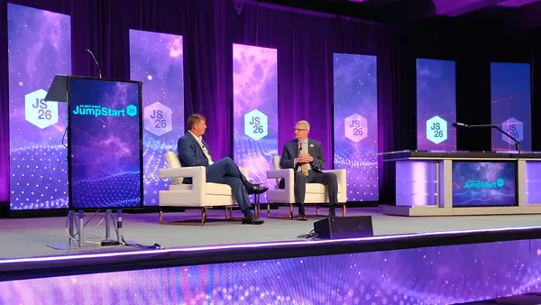 Clean Freight Coalition Executive Director Jim Mullen and FMCSA Administrator Derek Barrs sit on chairs for a conference talk.