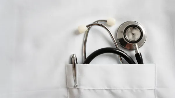 Stethoscope and pen in doctor robe pocket