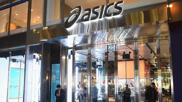 Lighted Asics store exterior, as seen from the outside at night.